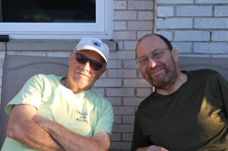 A father and son sitting together outside and smiling